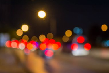 Arkaplan kullanımı için gece vakti renkli ışıkları olan bulanık sokak bokeh görüntüsü .
