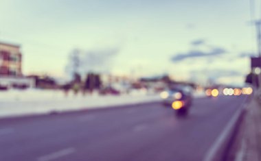 Arka plan kullanımı için akşam vakti yolda bulanık bir araba görüntüsü. (Klasik ton))