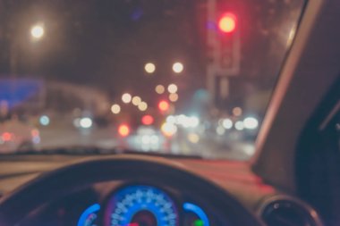 Arka plan için gece vakti trafik sıkışıklığından gelen bokeh ışıkları olan içerideki arabaların klasik ton bulanık görüntüsü.