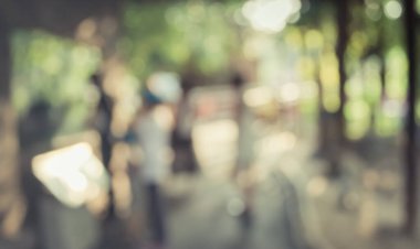 Arka plan kullanımı için Bokeh ile parkta yürüyen insanların klasik ton bulanık görüntüsü .