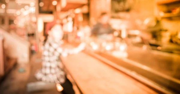 blur image of Abstract blurry sushi counter and customer  in vintage style decoration restaurant.