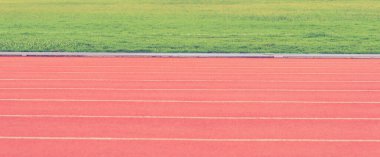 Arka plan dokusu için turuncu kauçuktan yapılmış atletizm pistinin klasik ton görüntüsü.