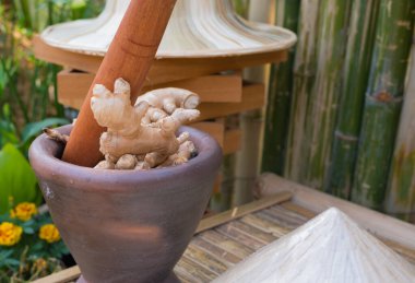 Ahşap zeminli havanda zencefil resmi.