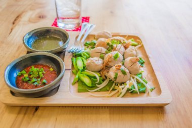 Tahta tabaktaki köfte resmi Tayland usulü acı sos ile ahşap masada..