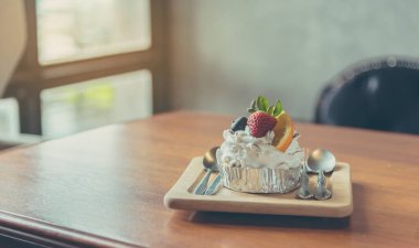 Böğürtlenli ve portakallı karışık meyveli kekin ahşap masa üzerindeki klasik tonu..