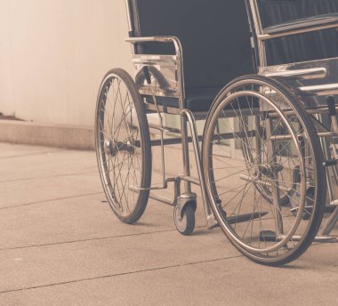 Arka plan kullanımı için hastane girişindeki boş tekerlekli sandalyenin klasik ton görüntüsü.