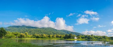 Güzelliğin panorama görüntüsü. Gölde güneşli bir gün. Bahar mevsiminde yağmurdan sonra yeşil dağ..