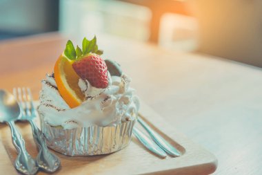 Böğürtlenli ve portakallı karışık meyveli kekin ahşap masa üzerindeki klasik tonu..