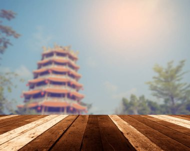 Ahşap masa ve klasik ton görüntüsü arka plan kullanımı için gündüz vakti güzel Çin tapınağının bulanık görüntüsü.