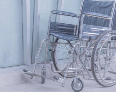 Arka plan kullanımı için hastane girişindeki boş tekerlekli sandalyenin klasik ton görüntüsü.