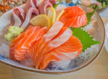 Tabakta buzda dilimlenmiş çiğ ve taze somon resmi..