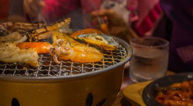 Demir rafta dilimlenmiş sığır eti ve kalamar ızgarası resmi .