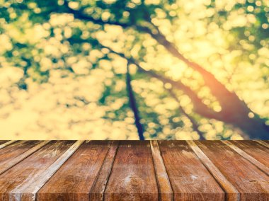 Arkaplan kullanımı için ahşap tablo ve yeşil ağaç bokeh 'in soyut bulanık resmi .