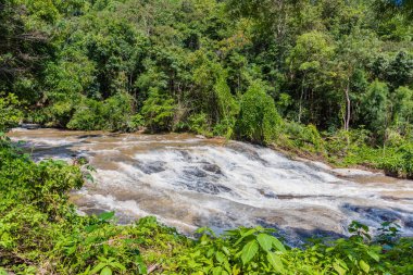 Şiddetli yağmurdan sonra nehirdeki yüksek hızlı su akışının uzun pozlama görüntüsü.