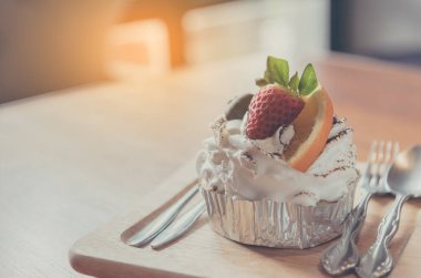 Böğürtlenli ve portakallı karışık meyveli kekin ahşap masa üzerindeki klasik tonu..