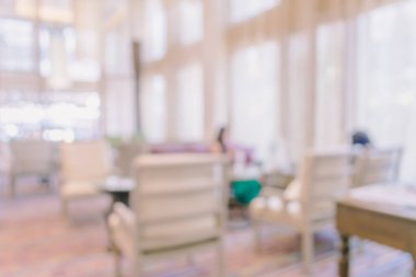 Arka planda oturma odasında oturan insanların bulanık görüntüsü.