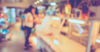 Kahve dükkanının arka planında Bokeh imajı olan bir müşteri. (Klasik ton))