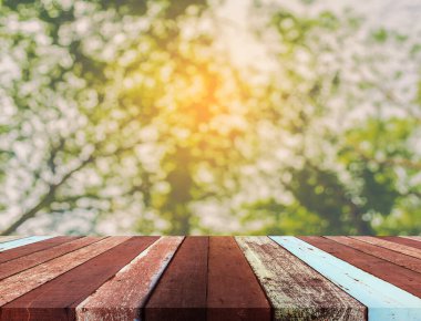 Arkaplan kullanımı için ahşap tablo ve yeşil ağaç bokeh 'in soyut bulanık resmi .