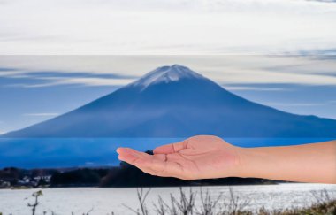 Boş erkek eli açılır ve arkadaki Fuji Dağı 'nın bulanık görüntüsü.