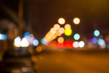 Arkaplan kullanımı için gece vakti ışıklandırmalı bulanık sokak bokeh görüntüsü .