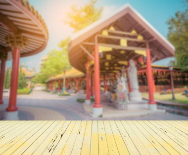 Ahşap masa ve klasik ton görüntüsü arka plan kullanımı için gündüz vakti güzel Çin tapınağının bulanık görüntüsü.