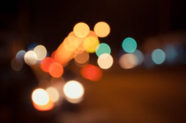 Arkaplan kullanımı için gece vakti ışıklandırmalı bulanık sokak bokeh görüntüsü .