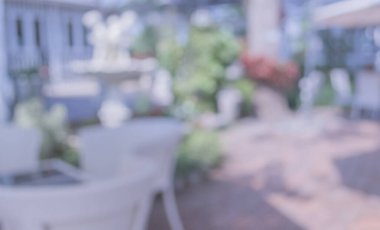 Arka plan kullanımı için yeşil ağaç bokeh ile gündüz vakti bulanık bir restoran görüntüsü .