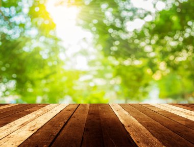 Yeşil bokeh arkaplanlı ahşap masa