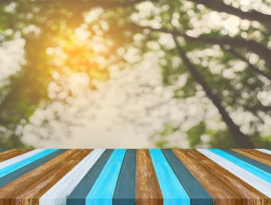 Arkaplan kullanımı için ahşap tablo ve yeşil ağaç bokeh 'in soyut bulanık resmi .