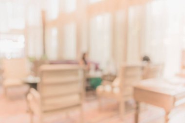 Arka planda oturma odasında oturan insanların bulanık görüntüsü.