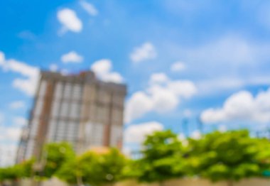 Arkaplanda bulanık bina ve mavi gökyüzü görüntüsü