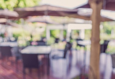 Arka plan kullanımı için yeşil ağaç bokeh ile gündüz vakti bulanık açık hava restoranının klasik ton görüntüsü .