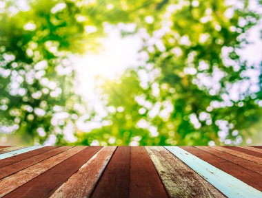 Arkaplan kullanımı için ahşap tablo ve yeşil ağaç bokeh 'in soyut bulanık resmi.