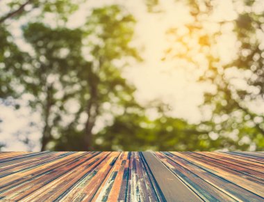 Arkaplan kullanımı için ahşap tablo ve yeşil ağaç bokeh 'in soyut bulanık resmi .