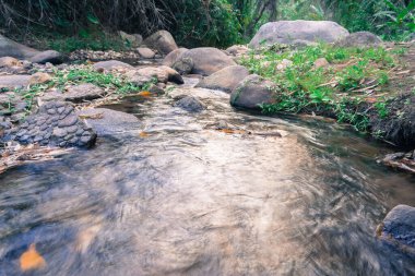 Gündüz vakti nehir ve kayanın uzun pozlama görüntüsü.