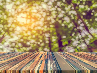 Arkaplan kullanımı için ahşap tablo ve yeşil ağaç bokeh 'in soyut bulanık resmi .