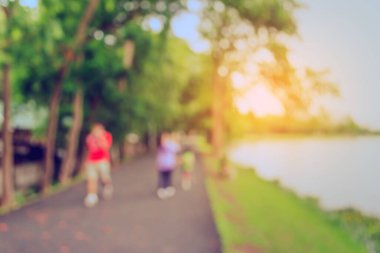 Arka plan kullanımı için Bokeh ile parkta egzersiz yapan kişilerin klasik ton bulanık görüntüsü.