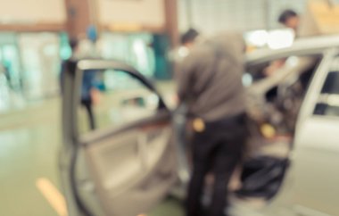 Garajda araba tamir eden akıllı telefon ve bulanık teknisyen resmi var..