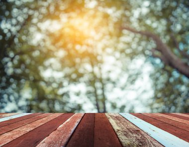 Arkaplan kullanımı için ahşap tablo ve yeşil ağaç bokeh 'in soyut bulanık resmi .