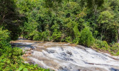 Şiddetli yağmurdan sonra nehirdeki yüksek hızlı su akışının uzun pozlama görüntüsü.