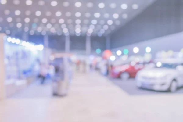 blur image of Commercially cars stand in show room of car shop for background usage.