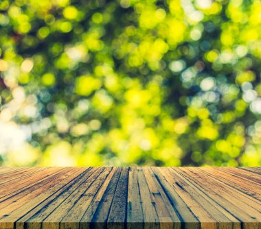 Ahşap tablo ve arkaplan kullanımı için güneşi olan soyut yeşil ağaç Bokeh 'in bulanık görüntüsü.