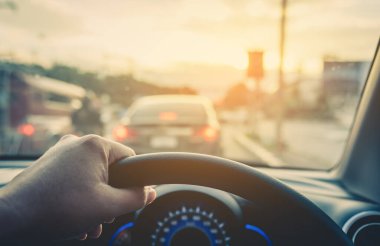 Arka plan kullanımı için gündüz vakti araba kullanan insanların klasik ton görüntüsü. (içeriden fotoğraf çek sürücü eline odaklan)