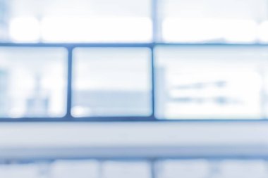 Abstract blur blue tone image of bright and clean Window in modern office building on day time for background usage.