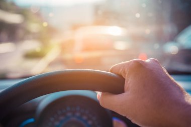 Arka plan kullanımı için gündüz vakti araba kullanan insanların klasik ton görüntüsü. (içeriden fotoğraf çek sürücü eline odaklan)