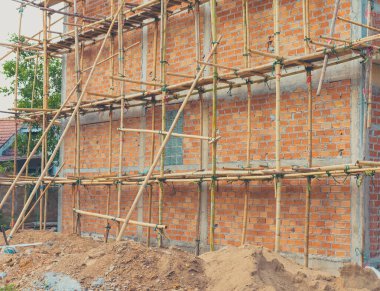 vintage tone image of building under construction and bricks on day time.