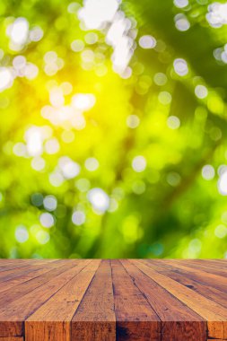 Arkaplan kullanımı için ahşap tablo ve yeşil ağaç bokeh 'in soyut bulanık resmi .