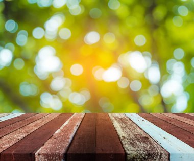 Arkaplan kullanımı için ahşap tablo ve yeşil ağaç bokeh 'in soyut bulanık resmi .