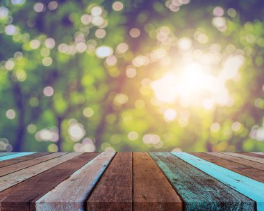 Arkaplan kullanımı için ahşap tablo ve yeşil ağaç bokeh 'in soyut bulanık resmi .