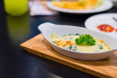 image of spinach and cheese bake casserole on wooden plate.